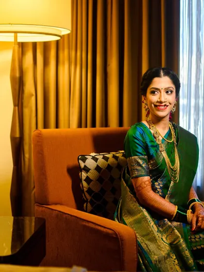 A beautiful seated portrait of the bride, Shruti. The warm, ambient light of the hotel room at the Sheraton Grand Pune created a perfect, soft glow.