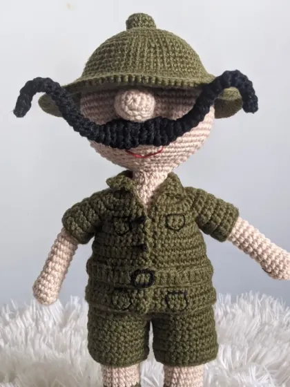 A crochet doll of the classic Indian comic character, Shikari Shambhu, with his green safari outfit and magnificent mustache.