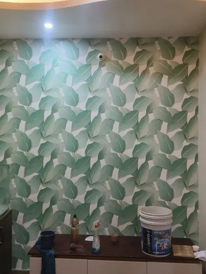 A bold, large-scale green leaf wallpaper makes this wall a vibrant focal point. The pattern is perfect for creating a lush, jungle-inspired look in a modern home.