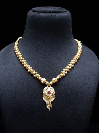 A delicate gold-beaded necklace with a small, intricate pendant. This is a perfect piece for those who prefer minimalist yet traditional jewellery.
