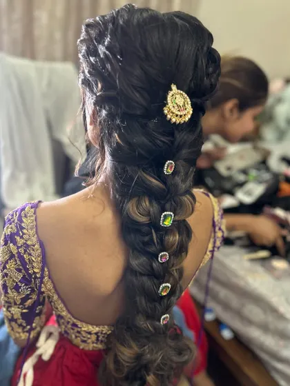 An intricate braid with beautiful Navratna-style gems placed along its length. This is a great way to customize a hairstyle to match a client's outfit.