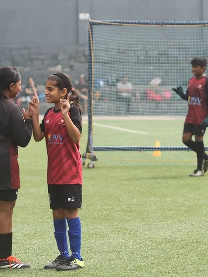 Friendship and fun at the Summer Camp. Two players share a lighthearted moment between drills.
