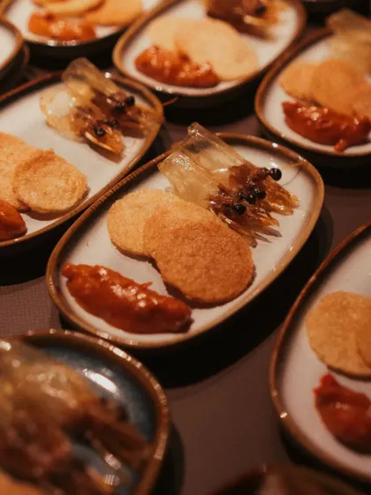 A small plate designed to pack a punch. This dish features crispy fried prawn heads, prawn crackers, and a house-made sambal for a spicy, crunchy, and succulent bite.