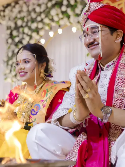 The bride and groom participate in the homa (sacred fire) ritual, their faces reflecting reverence and happiness.