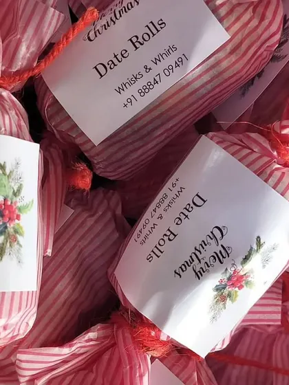 A close-up of our custom "Merry Christmas" stickers on individually wrapped date rolls. It's all in the details.