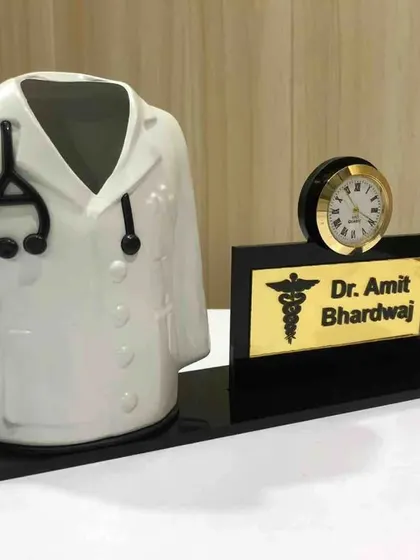 A thoughtful gift for doctors. This pen stand features a miniature doctor's coat and a personalized nameplate with a clock.
