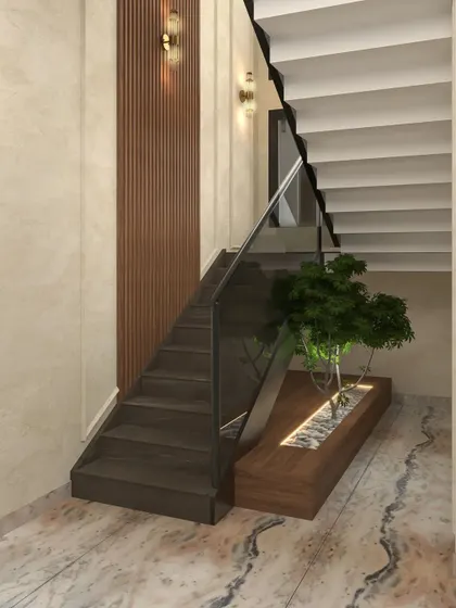 This duplex apartment staircase combines dark wooden steps with a glass railing and is enhanced by a built-in planter with a small tree.