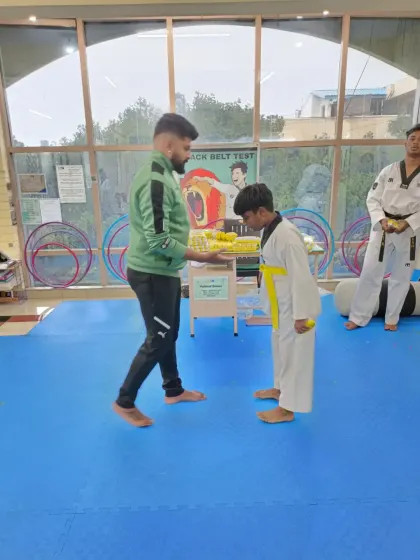 A young student bows after receiving his yellow belt.