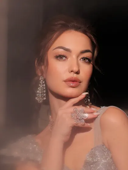 A close-up on the model's face, her diamond jewelry sparkling in the light.
