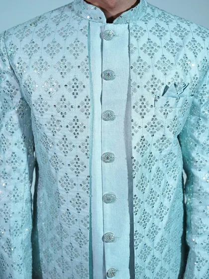 A close-up of the light blue sherwani, highlighting the intricate silver embroidery and beautiful buttons.