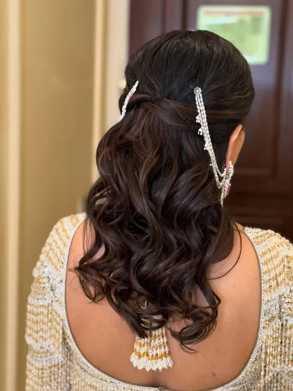 A simple and elegant half-up style, adorned with a beautiful silver hair accessory. This look is perfect for a sophisticated evening event.