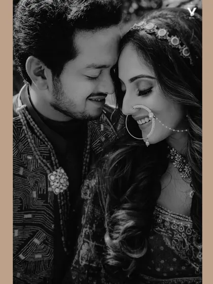 A tender black and white close-up of a couple, their faces touching, capturing a quiet moment of love and happiness. The intricate details of the bride's nath and jewelry add to the beauty of this Indian wedding portrait.