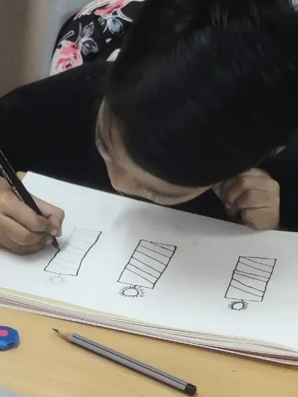A student practicing drawing basic shapes. Mastering these fundamentals is the first step towards creating more complex artwork.