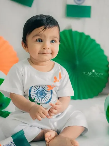 A gentle, sweet smile as the baby looks slightly away from the camera. The soft lighting and calm expression create a very endearing portrait.