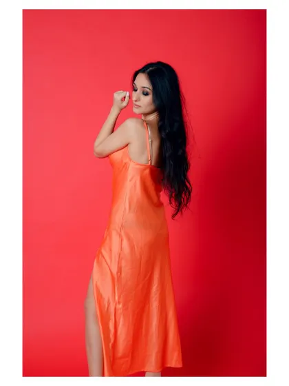 A glamorous portrait in a vibrant orange dress. The pose is elegant and the color is eye-catching.