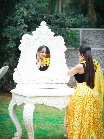 A creative pose from a photoshoot. The makeup is kept fresh and glowing to complement the vibrant yellow outfit, while the sleek ponytail adds a touch of modern elegance.