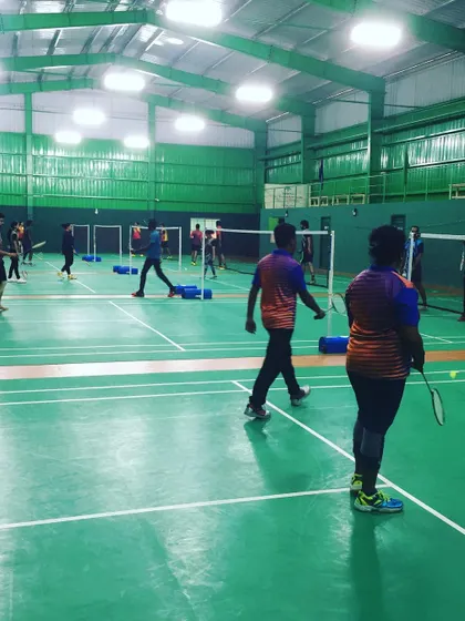 A view of the courts filled with players during a company event. The vibrant green of the courts and the active participants create a visually energetic atmosphere.