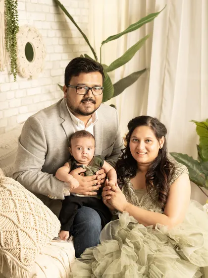 A beautiful family of three in a cozy, bohemian-style studio setting. This portrait captures the warmth and love of a new family.