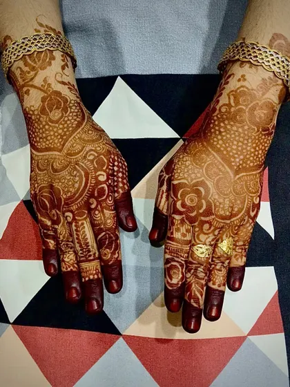 A detailed look at a bridal-style henna stain. The intricate patterns, dots, and floral motifs are all beautifully defined by the rich, dark color.