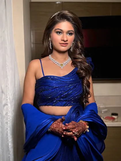 The full look, showcasing the stunning blue lehenga and the confident pose of my bride. The hair is styled in soft waves to balance the drama of the makeup and outfit.