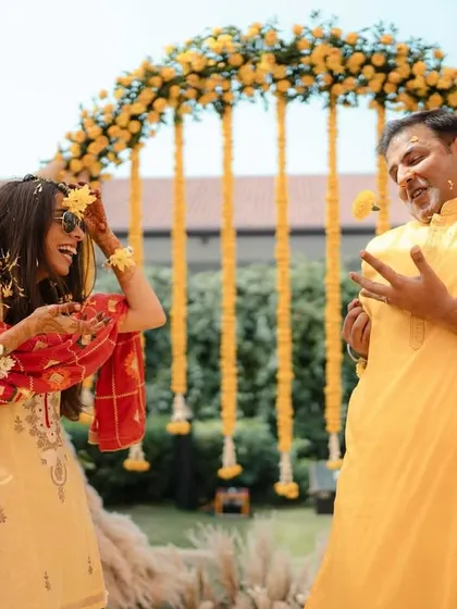 The couple sharing a playful moment, throwing flowers at each other before the Haldi paste comes out.