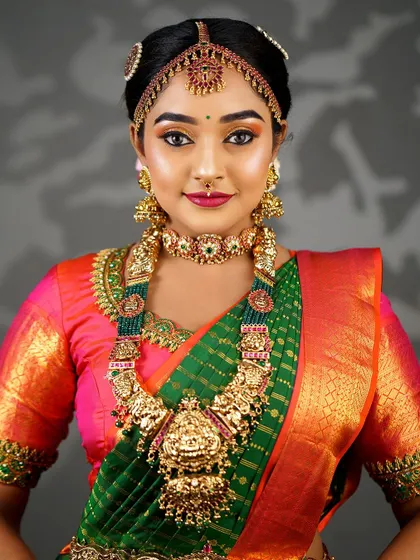 A portrait of a bride showcasing the harmony between makeup, jewellery, and attire. The warm tones in the makeup pick up the colours of the green and orange saree.