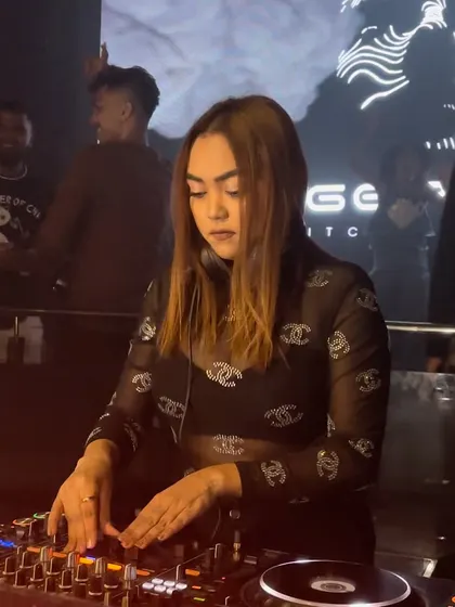 Another angle showing my hands on the Pioneer DJ gear, with the club's visuals in the background.