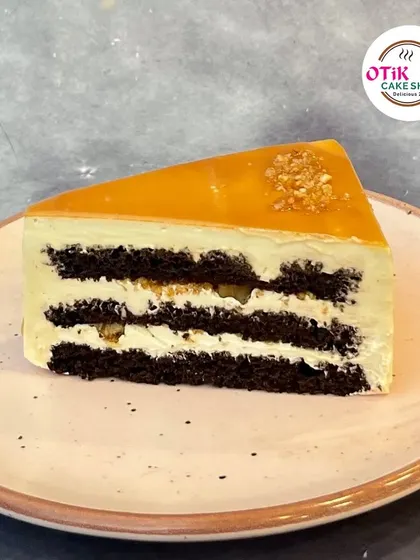 A slice of our Butterscotch Pastry. This classic flavor features layers of light sponge, creamy butterscotch frosting, and a topping of crunchy butterscotch bits.