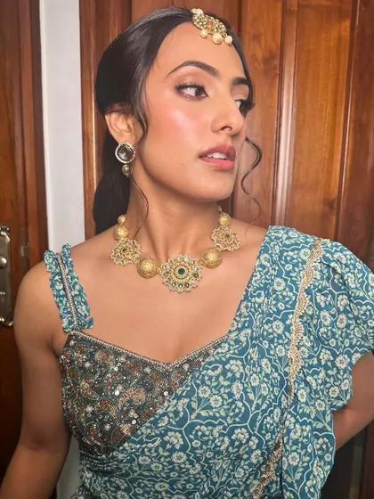 A chic Mehendi look with soft, bronzed makeup and a stylish maang tikka, perfect for a modern celebration.