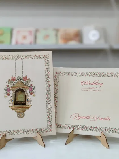 This pastel invitation features a traditional hanging Jharokha with floral details. It's a perfect blend of royal and romantic themes.