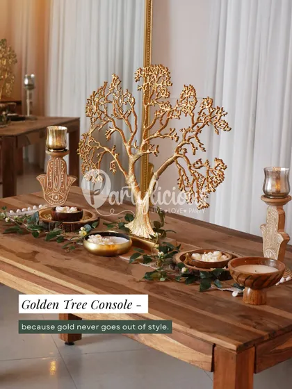 Gold never goes out of style, especially during the festive season. This golden tree console acts as a stunning centerpiece for a dining or entryway table, complemented by Hamsa hand candle holders.