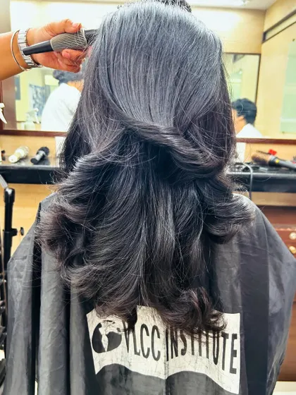 The process of blow-drying an advanced layered haircut, showing how each section is carefully styled to build volume and shape.