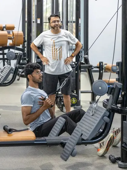 One-on-one coaching is a key part of our programs. Here, an athlete receives personalized instruction on a seated row machine, ensuring he targets the right muscles for improved posture and strength.