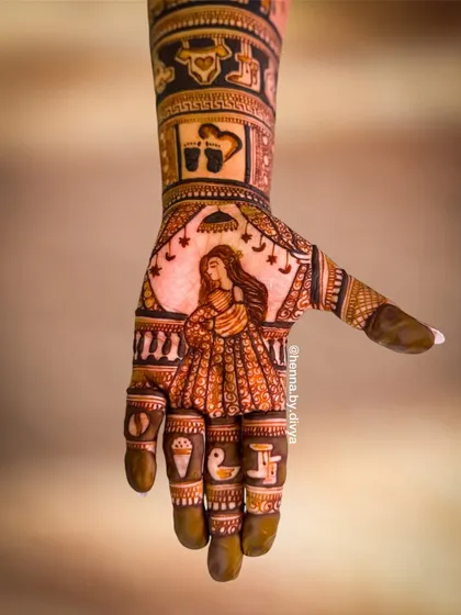 A single-hand close-up of a Godh Bharai mehendi, showing a detailed portrait of an expecting mother. The fingers include small, meaningful symbols like a duckling and an ice cream cone.