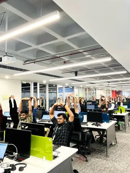 The team at MRI Software fully engaged in an overhead stretch, a testament to the session's engaging nature.