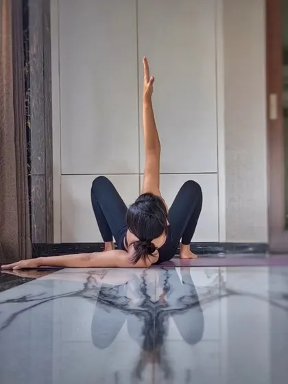 A seated twist that opens the shoulders and stretches the sides of the body. The reflection in the floor adds a beautiful symmetry to the pose.