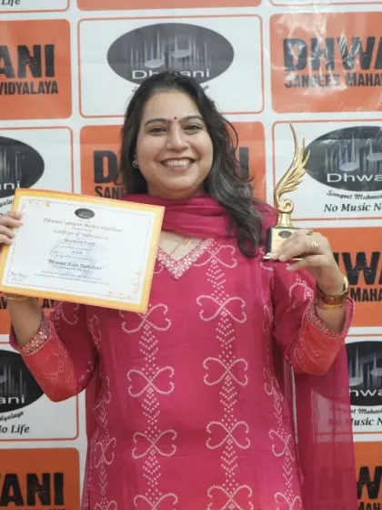 An adult student proudly holds her certificate and trophy.