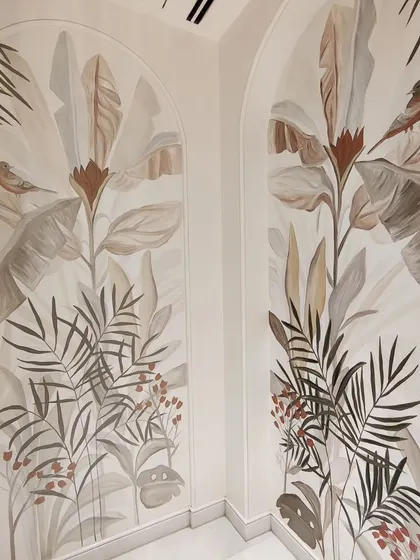 A beautiful shot of a completed tropical mural in muted tones, painted inside two arches at the DLF Camellias.