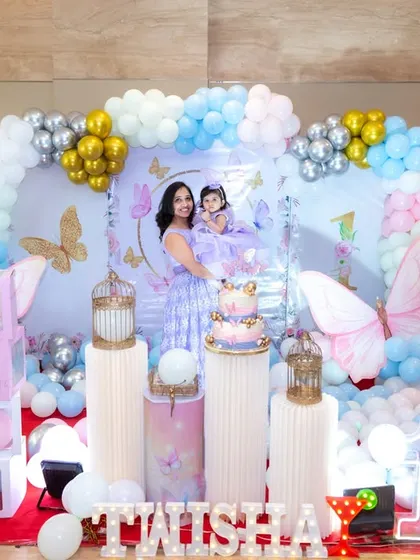 A wide shot of another beautiful butterfly-themed first birthday, showcasing the balloon arch and personalized backdrop. We love seeing how each family brings a unique touch to popular party themes.