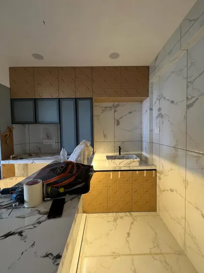 An in-progress shot showing the combination of wood-textured and frosted glass cabinets being installed. This highlights our use of mixed materials to add depth and visual interest to our kitchen designs.
