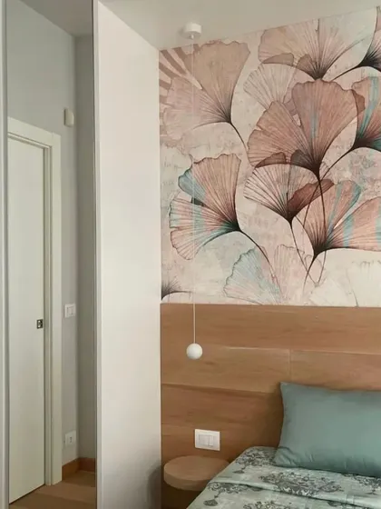Another angle of the ginkgo leaf wallpaper, showing how it beautifully frames the sleeping area and integrates with the modern, minimalist decor.