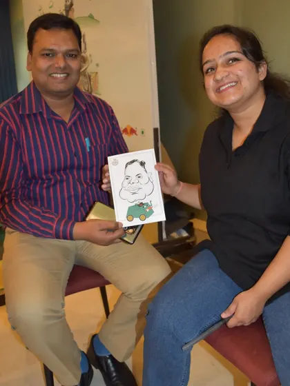 Posing with a happy client and her finished caricature at a corporate gathering.