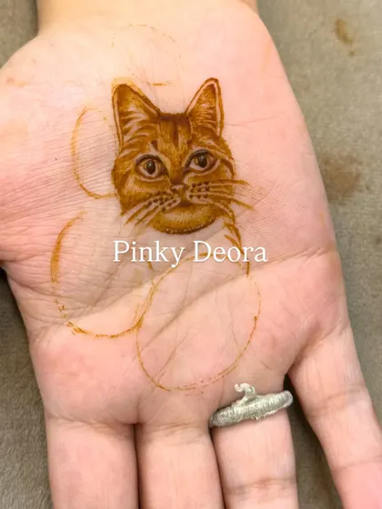 The initial outline of the cat portrait. This image shows the first steps in creating a detailed and characterful pet mehndi design.
