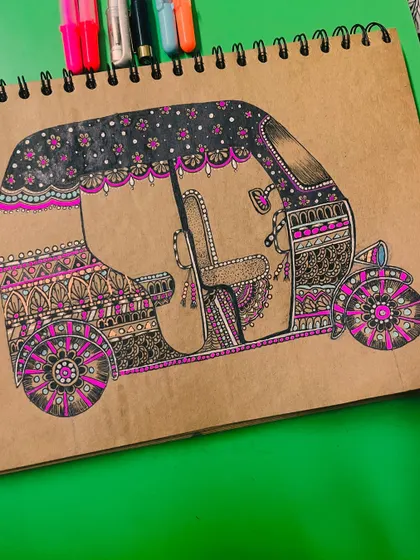 A decorated Indian auto-rickshaw filled with intricate mandala and doodle patterns.