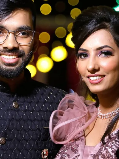 A classic couple portrait against a bokeh background of colorful lights at their evening reception.