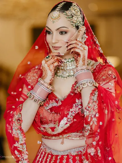 A close-up of the bride adjusting her nose ring, a classic and beautiful shot highlighting her intricate jewelry.