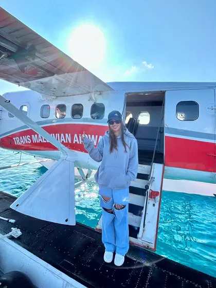 A solo shot on the seaplane's pontoon, with the beautiful Maldivian waters in the background.