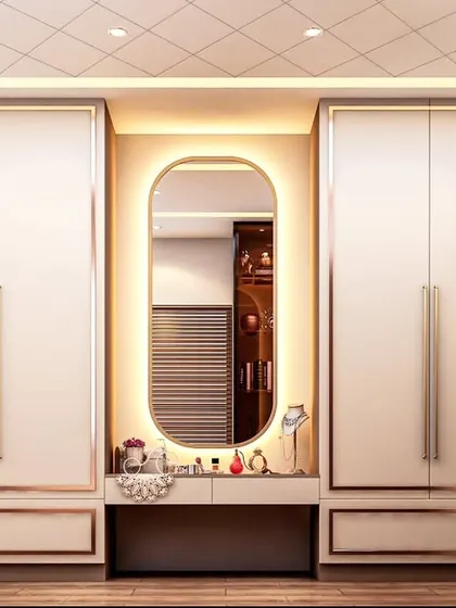 A practical and stylish wardrobe solution with an integrated dressing table. The white cabinets are framed with a subtle metallic finish, and the backlit oval mirror provides perfect lighting for the vanity area.