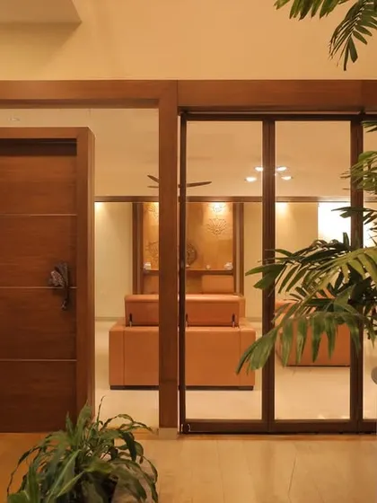 The entrance to the Ekta Residence living area, viewed from the courtyard. We used a combination of glass partitions and solid wood doors to create a layered, transitional space that feels both open and private.