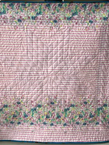 The back of the Glowing Star quilt, featuring a pink striped fabric.
